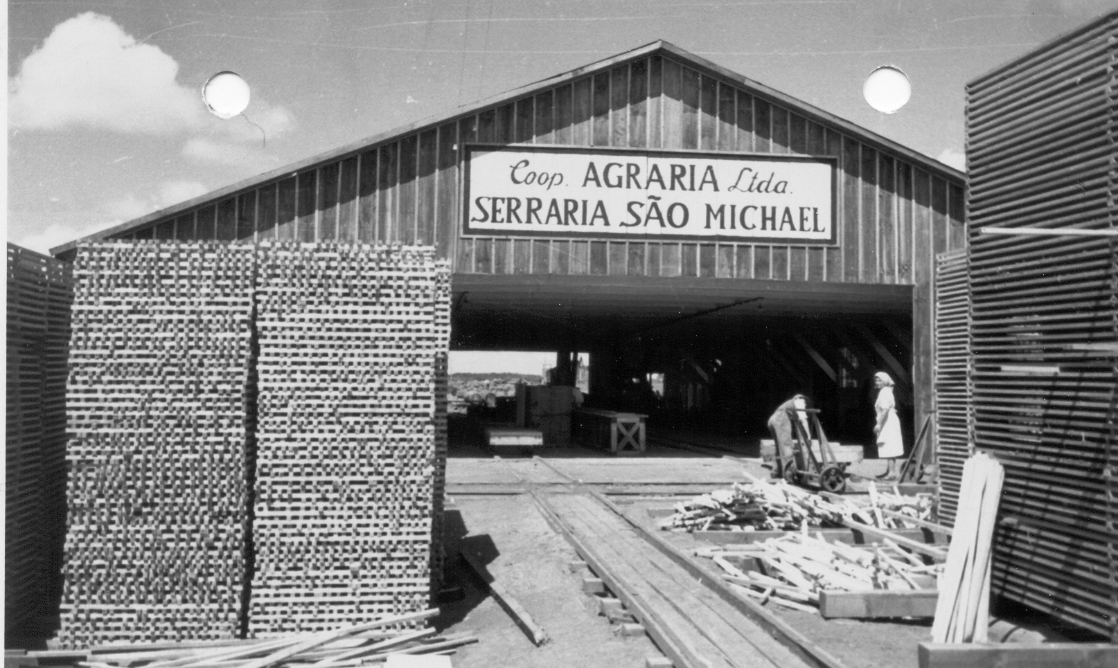 Das Sägewerk der Agrária verarbeitete bereits im Oktober 1951 eigenes Holz, das zum Bau der Häuser verwendet wurde.<br/><br/>A serraria da Agrária já processava sua própria madeira em outubro de 1951, destinada à construção das casas.<br/>